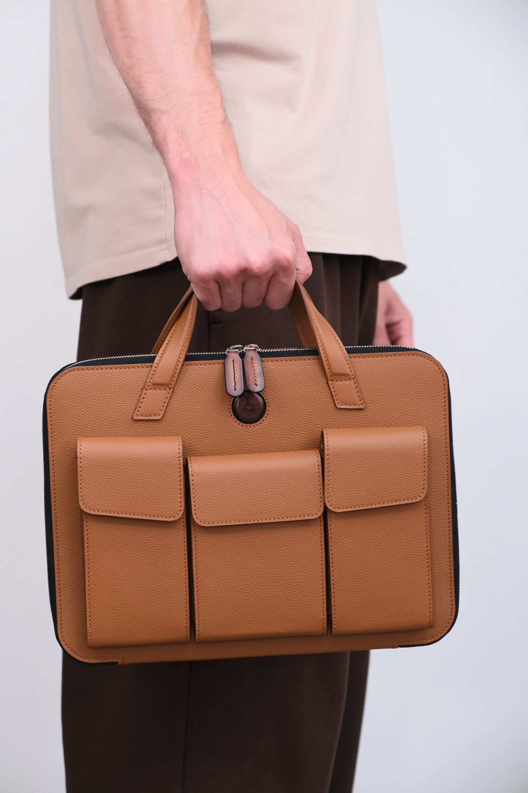 Светло-коричневая сумка Packmaster в руке